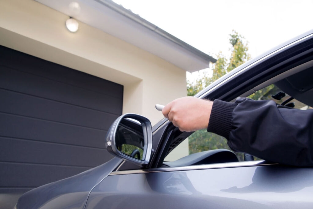 Male hand opening a garage door with a remote